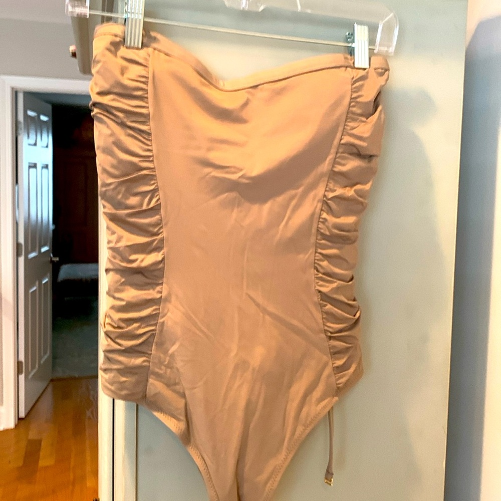 Tan one piece swimsuit with rushing details on side